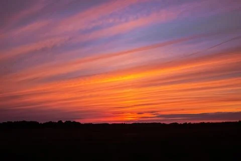 Last sunset of September, patterned colored evening sky. Stock Photos