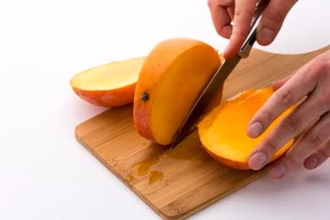 Last third of a mango cut off along its fruit pit Stock Photos
