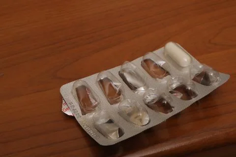 Last white capsule in empty medication blister pack 库存照片