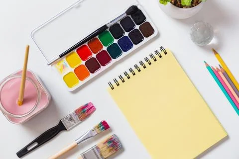 Lat Lay of Creative Art Tools with Yellow Notepad and Paint Stock Photos