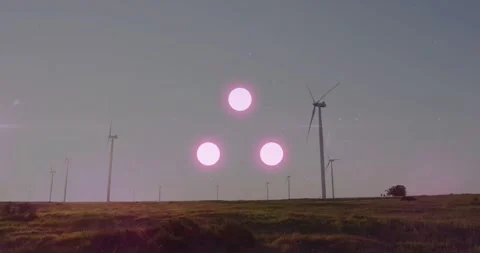 Late afternoon sunlight striking wind farm turbines creating pink flare triad Stock Footage 332316552