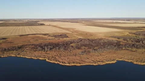 A late autumn view from a drone flying forward over a dark blue lake  Stock Footage 275833805