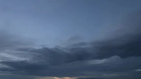 Late day blue hour timelapse of dark blue-gray clouds moving across the sky Stock Footage 312076594