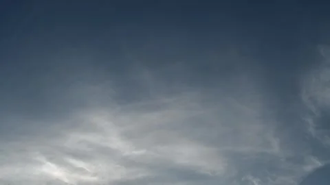 Late day cirrus clouds lit by a low angle sun drifting across a summer sky Stock Footage 311128567