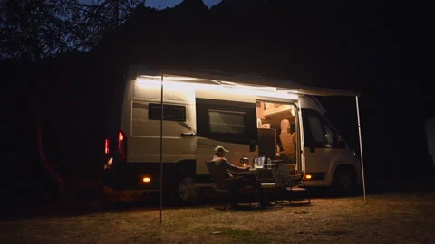 Late Evening On-line Remote Work in Front of Modern Camper Van While on Camping Stock Footage 141021576