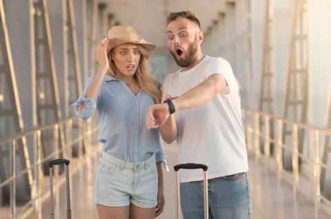 Late for flight. Couple checking time on watches Stock Photos