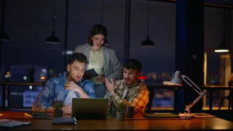 Late managers looking computer screen dark office. Overtime inspired colleagues Stock Footage 339299572