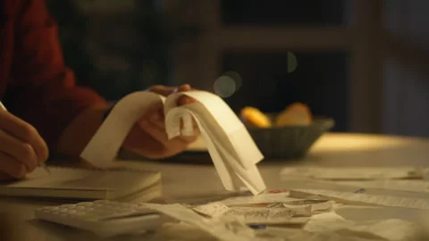 Late night expense tracking and budgeting with receipts at a dimly lit table Stock Footage 323866438