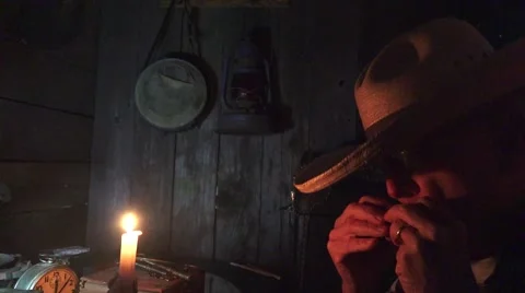 Late Night Playing Harmonica by candle light Stock Footage 58759803