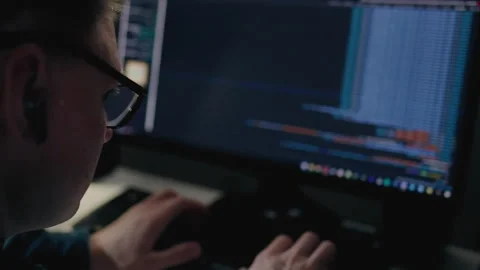 Late into the night, a programmer sits at their desk illuminated by the soft Stock Footage 241723734