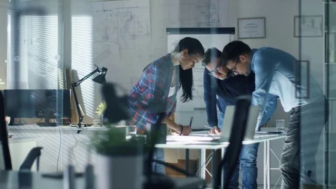 Late at Night Three Design Engineers Have a Working Meeting about Project.  Stock Footage