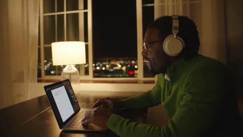 Late night typing session with laptop and lamp in cozy home office setting Stock Footage 312583398
