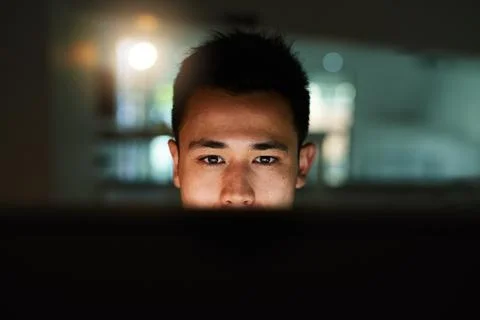 Late night work session. Shot of a handsome young male programmer working lat Stock-Fotos