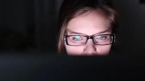 Late night working on computer screen reflected in woman's face, dolly shot Stock Footage 64287540
