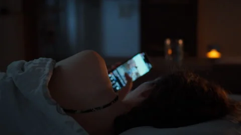 Late at night a young woman cannot sleep and scrolls through social media on Stock Footage 345577957