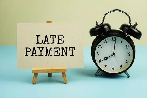 Late payment text message written on paper card with alarm clock for busine.. Stockfoto's