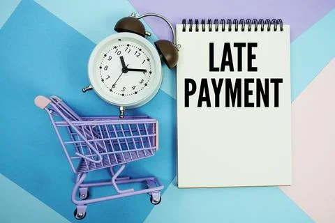 Late Payment text written on notepad with alarm clock and trolley shopping ca Foto stock