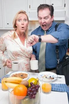 Late for Work Stressed Couple Checking Time in Kitchen. Stock Photos