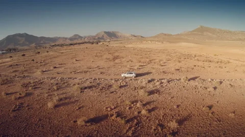 Lateral aerial view of a moving 4 by 4 car  through an arid land. Spain. 4k Stock Footage 44790981