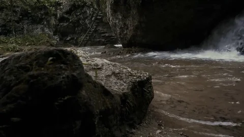 Lateral camera movement overlooking a small waterfall in the mountains Stock Footage 76660791