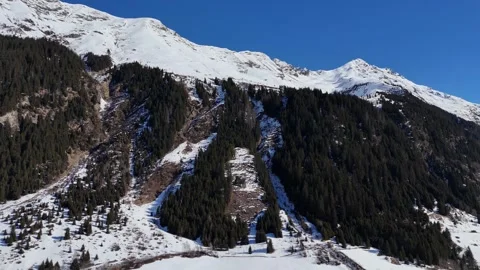 Lateral Drone Flight Along Snow-Covered Alpine Mountain Ridge Stock Footage 332124321