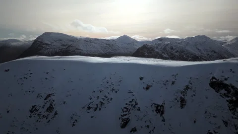 Lateral drone movement over distant hiker on snowy mountains near Glencoe Видео 335967118