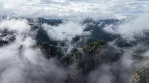 Lateral Drone Shot of Gubongsan in Clouds with Suspension Bridge, South Korea Stock Footage 345867466