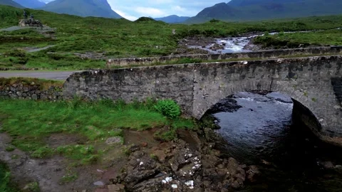 Lateral drone shot moving left to right along Sligachan stone bridge with river Stock Footage 330871181