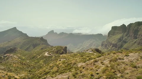 Lateral flight over big deep canyon, mountain house and curvy road Video stock 90662632