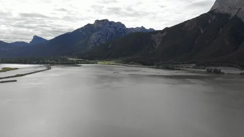 Lateral move over Bow River Alberta, towards a highway with rockies in BG. Video stock 113011863