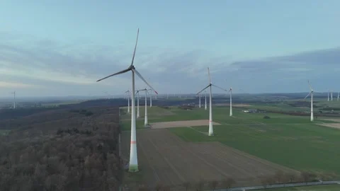 Lateral pass above fields forest edge and turbine rows Stock Footage 331215163