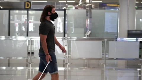 Lateral shot of a middle aged man walking through the airport terminal carryi 스톡 동영상 136393620