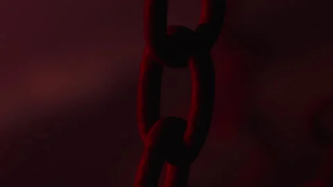 Lateral trcking shot of chains with a red flashing light, like an alarm Stock Footage 337727245