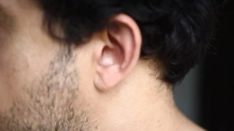 A lateral view from a bearded man putting a wireless headphone on his ear   Vídeo Stock 218641668