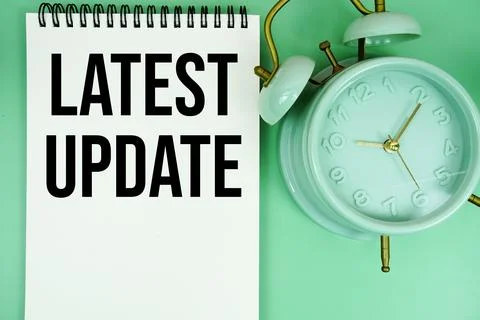 Latest Update text with alarm clock flat lay on green background 스톡 사진