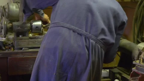 A lathe machine in action in a workshop, with a craftsman turning a metal p.. Stock Footage 282896630