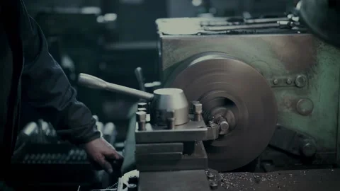 Lathe machine operates with metal part under worker control Stock Footage 133736400