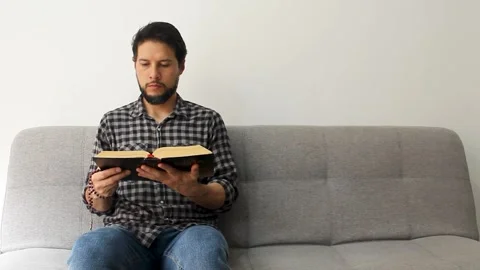 Latin believer man reading the holy bible with a rosary in his hand Vídeo Stock 340583499
