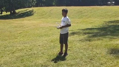 Latin boy operating a drone with remote control. Quadro copter drone flying over 库存影片 97938550