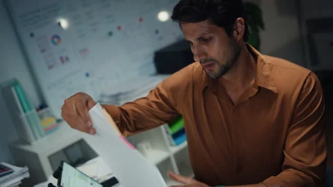 Latin businessman working late on document at office night. 库存影片 340971215