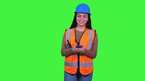 Latin construction worker woman using smartphone on green screen Stock Footage 308743373