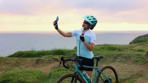 Latin cyclist taking a selfie at sunset by the sea Stock-Footage 309817874