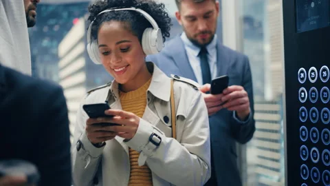 Latin Female Riding Elevator Using Smartphone Stock Footage 167553963