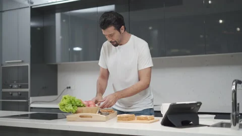 Latin handsome man cooking  breakfast healthy food spread bread with tuna wit Stock Footage 168620025