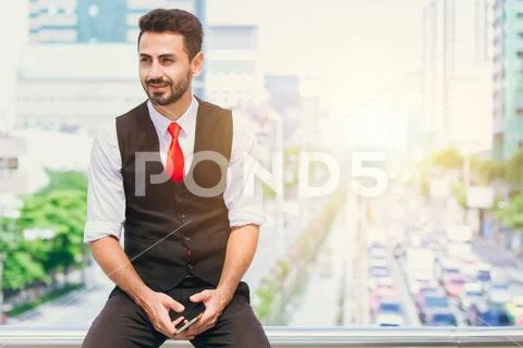 Latin hispanic businessman sitting smile with city blur background hand hold Stock Photos