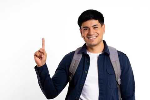 Latin man, carrying a backpack, points with his finger to copy space Stock Photos