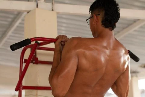Latin man doing pull-ups. concept of strong and muscular man. Stock Photos