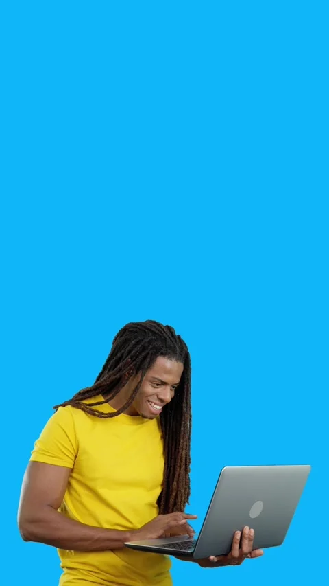 Latin man with dreadlocks smiling while using a laptop Stock Footage 254953854