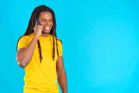 Latin man with dreadlocks smiling while talking to the mobile Stock Photos
