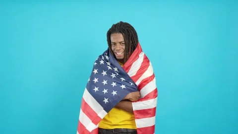 Latin man with dreadlocks wrapping with north america national flag Stock Footage 245102089